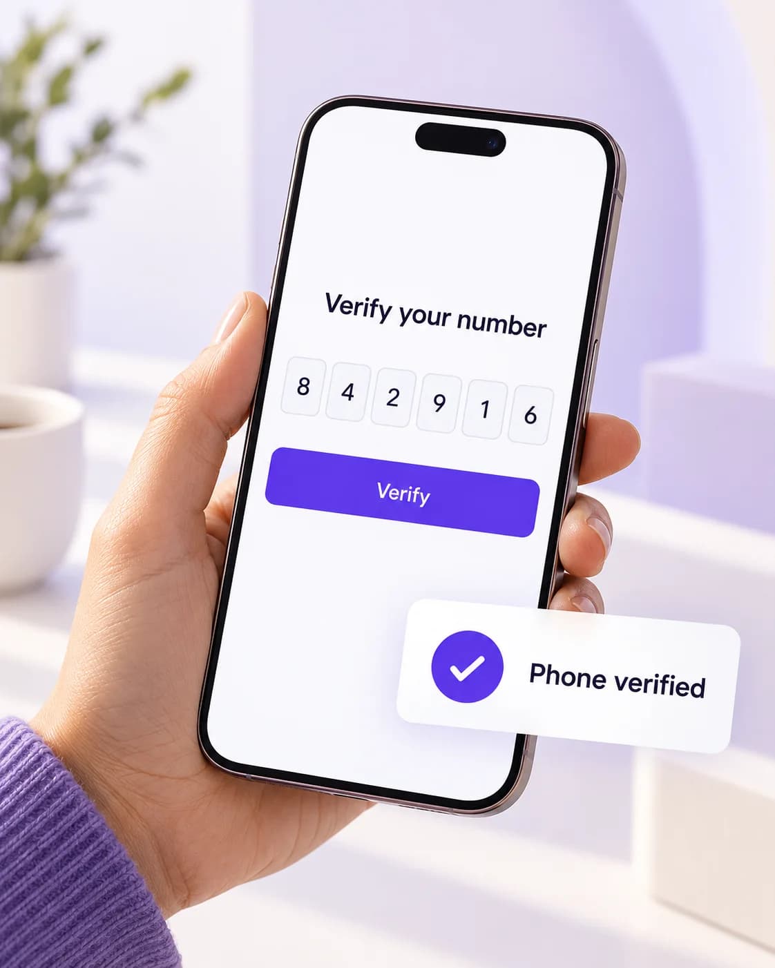 A hand holding a phone with a number-verification screen and confirmation