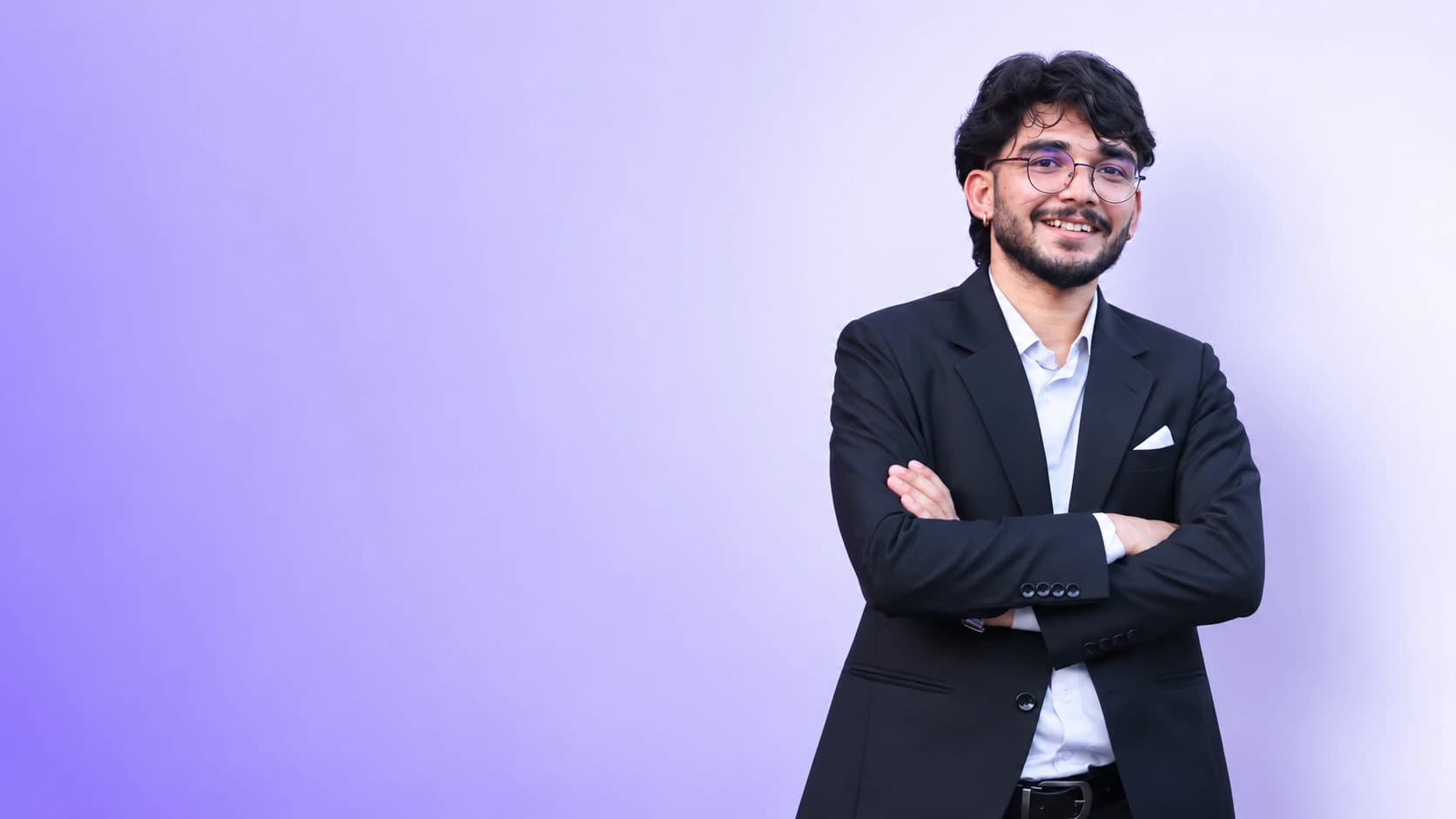 Dinesh Uprety in a black suit against a lavender studio background